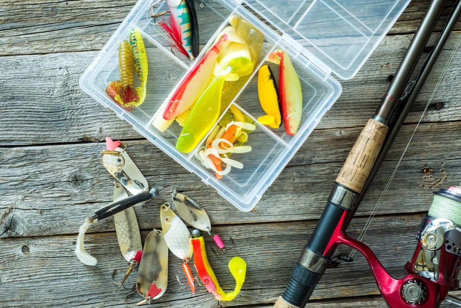A box of fishing lures and a fishing rod.